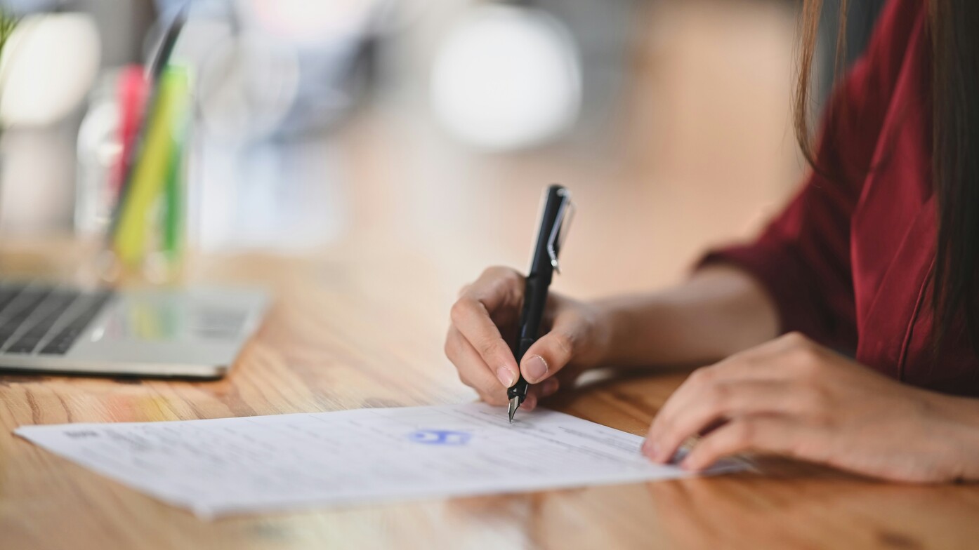 A person reviewing notes and documents at a desk, representing the process of understanding and documenting everyday functional challenges."